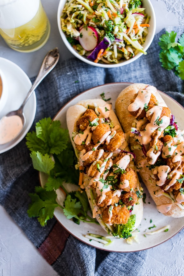 This Asian shrimp po boy sandwich is packed full of flavor and perfect for the busy weeknight meal planning. First, you take a crusty roll and pack it full of a crunchy Asian flavored broccoli slaw, top with crispy baked shrimp and drizzle with spicy Sriracha mayo. You'll love this sandwich!