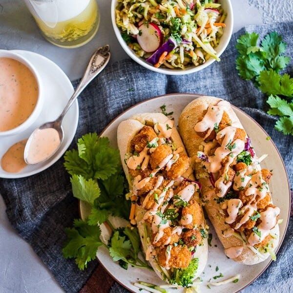 This Asian shrimp po boy sandwich is packed full of flavor and perfect for the busy weeknight meal planning. First, you take a crusty roll and pack it full of a crunchy Asian flavored broccoli slaw, top with crispy baked shrimp and drizzle with spicy Sriracha mayo. You'll love this sandwich!