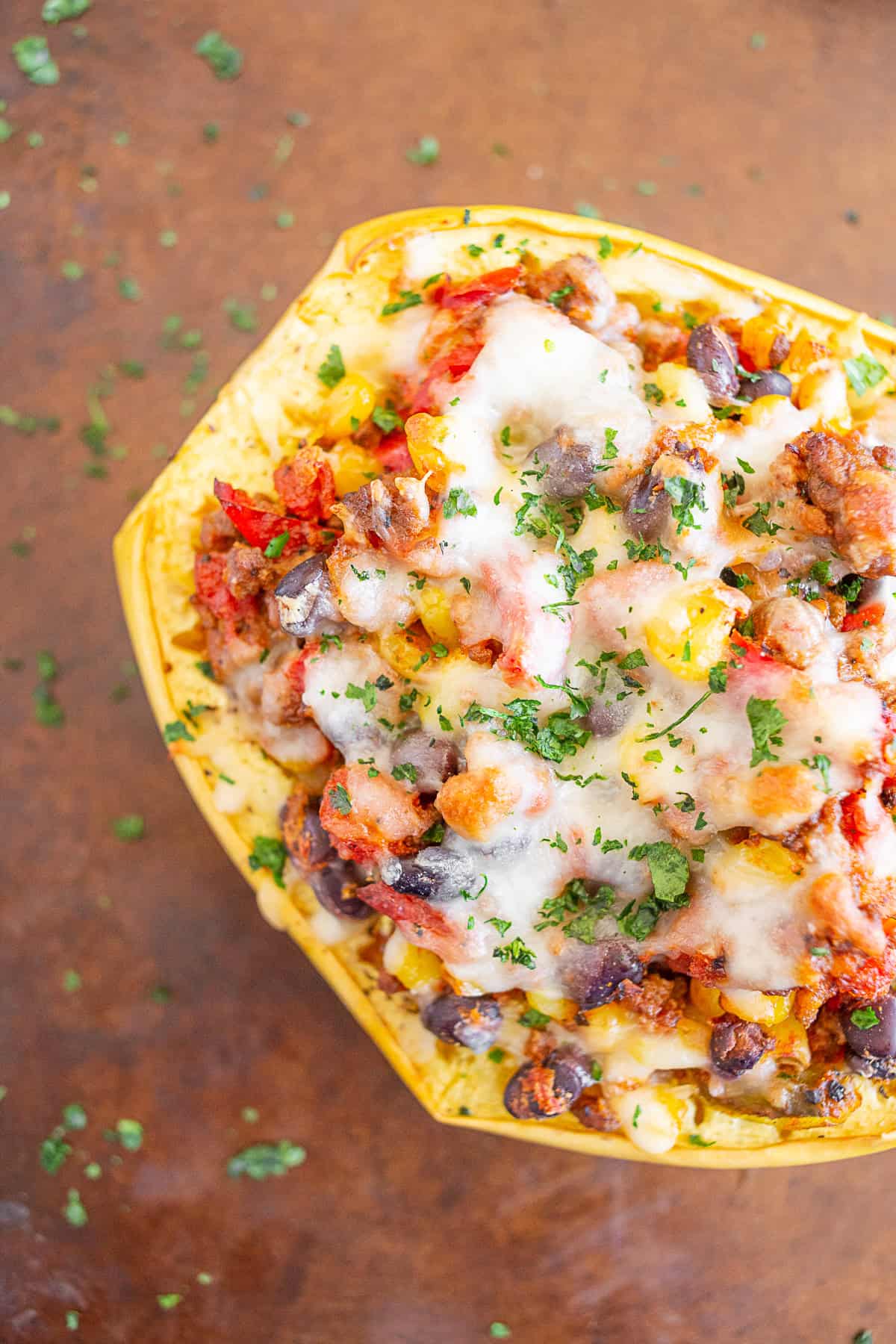southwest taco stuffed spaghetti squash topped with cheese on a sheetpan