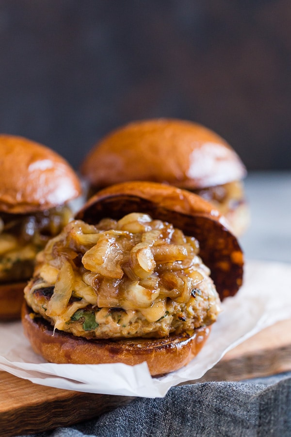 Apple Butter Onion Chicken Burgers on a bun topped with smoked cheese and onions. 