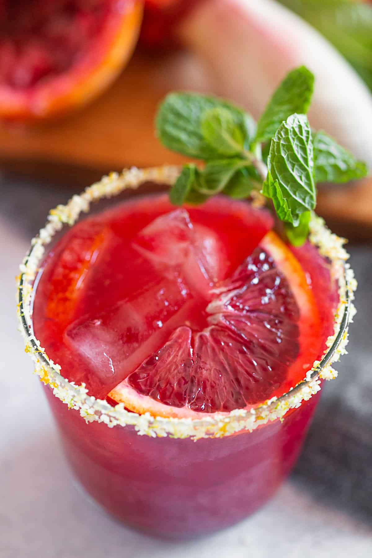Blood Orange Margarita in a glass with mint to garnish.