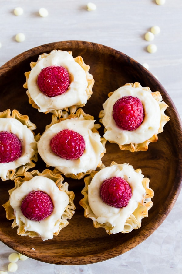 No Bake White Chocolate Cheesecake Bites served on a wooden tray.