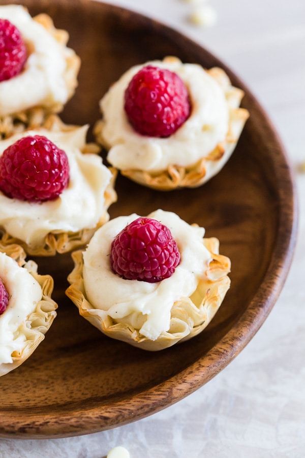 No Bake White Chocolate Cheesecake Bites on a wooden plate.