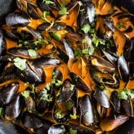 These red curry coconut milk mussels are ready in just 35 minutes and are packed full of ginger, garlic, and lemongrass flavors. You'll be blown away by how easy they are to make and want to sop up every last drop of the red curry coconut milk sauce!