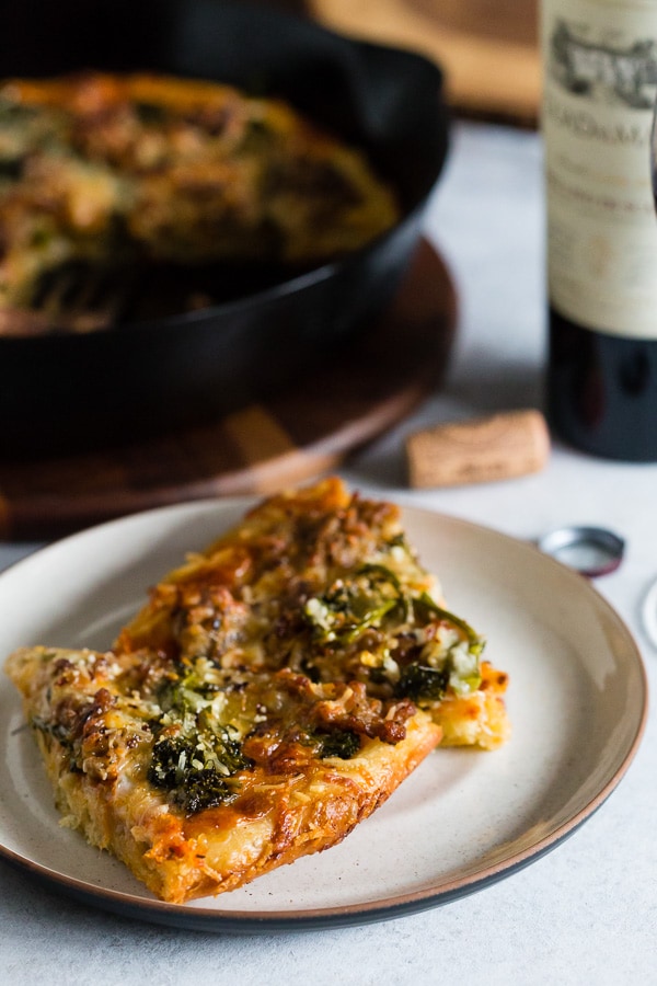 Sausage Broccoli Rabe Skillet Pizza sliced on a plate.