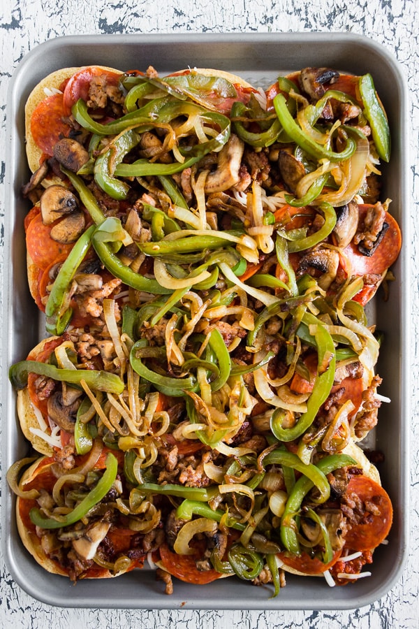 Baked Supreme Pizza Sliders piled high with ingredients. 