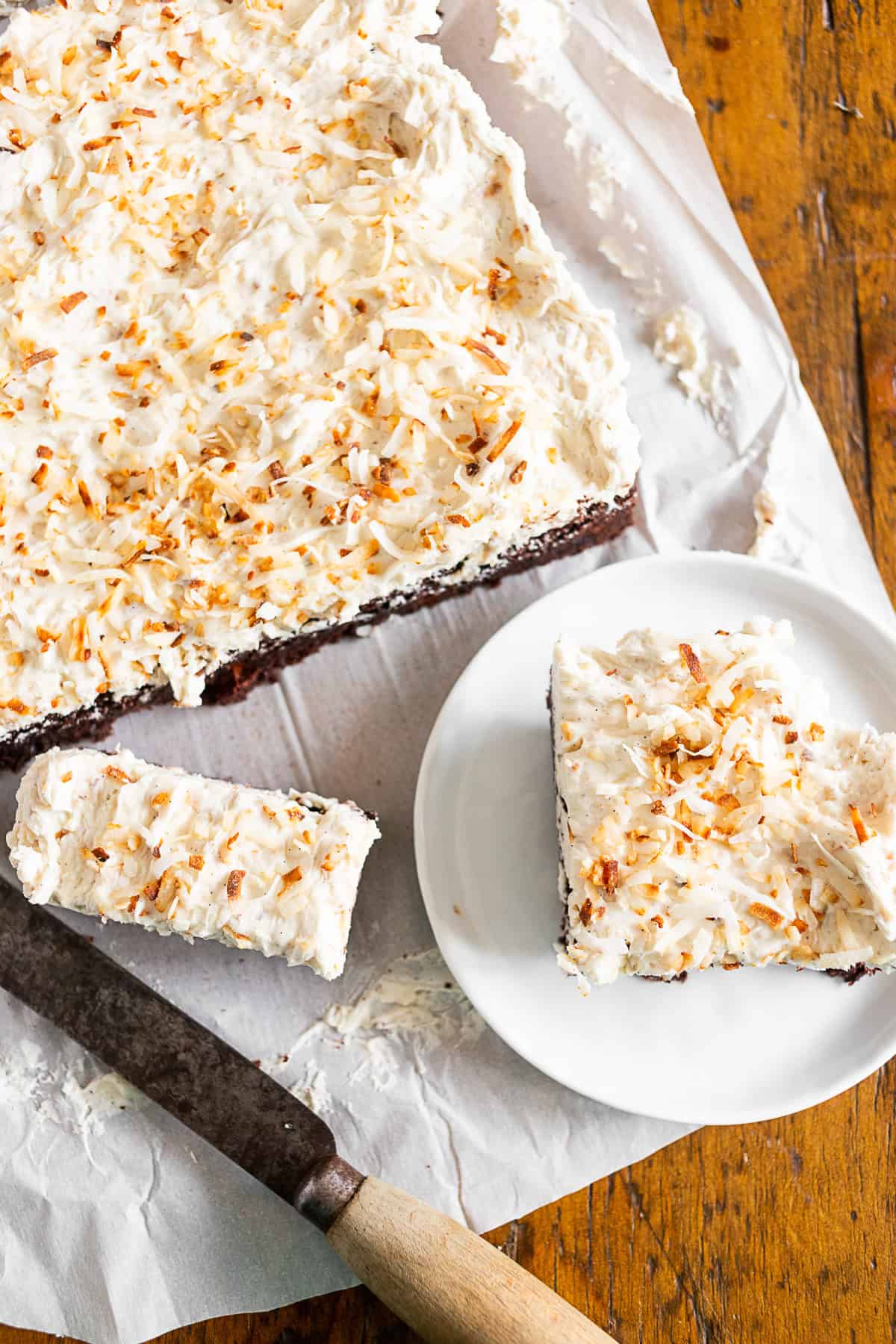 Fluffy Toasted Coconut Frosting sliced on a plate.