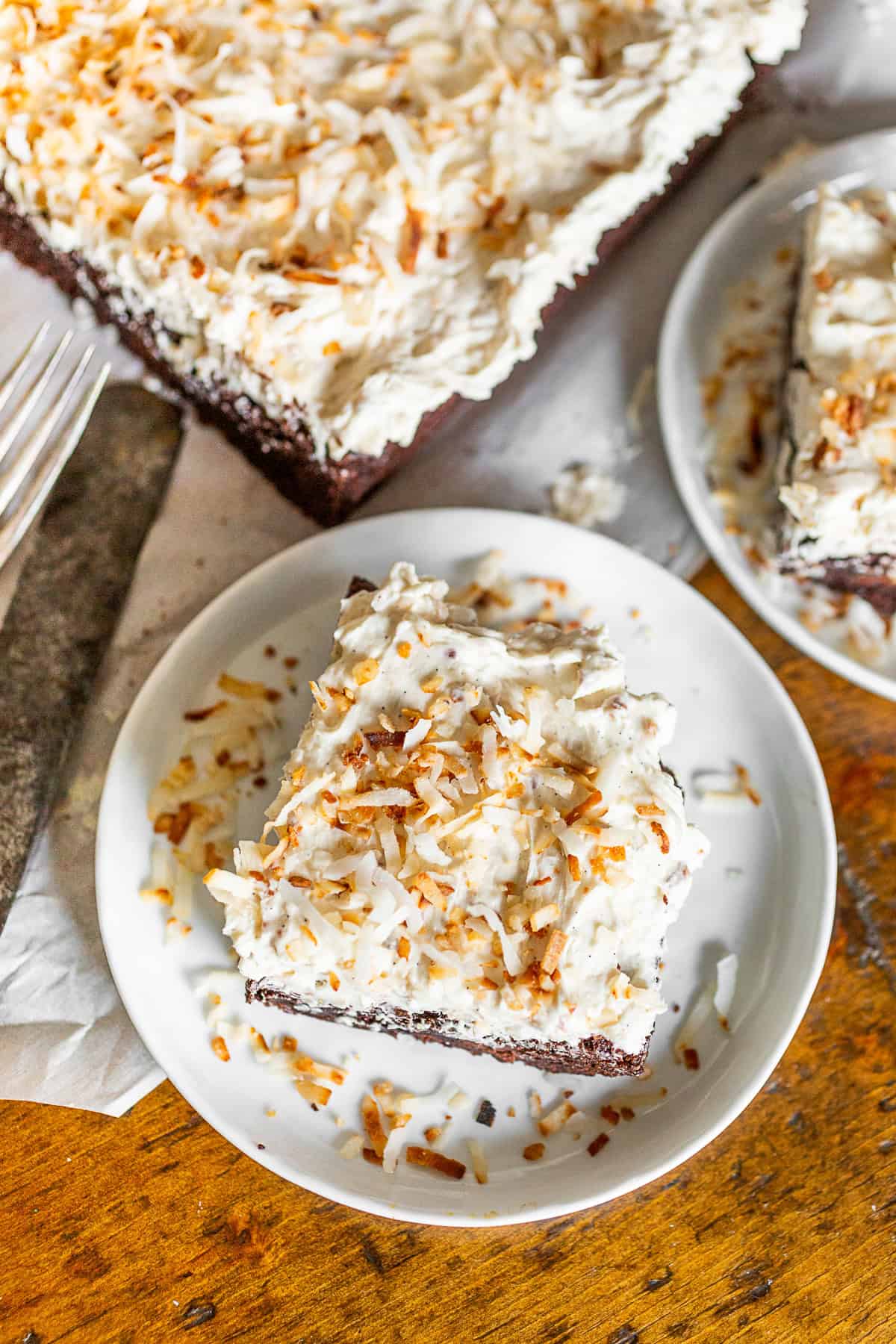 Fluffy Toasted Coconut Frosting on a brownie sitting on a plate.