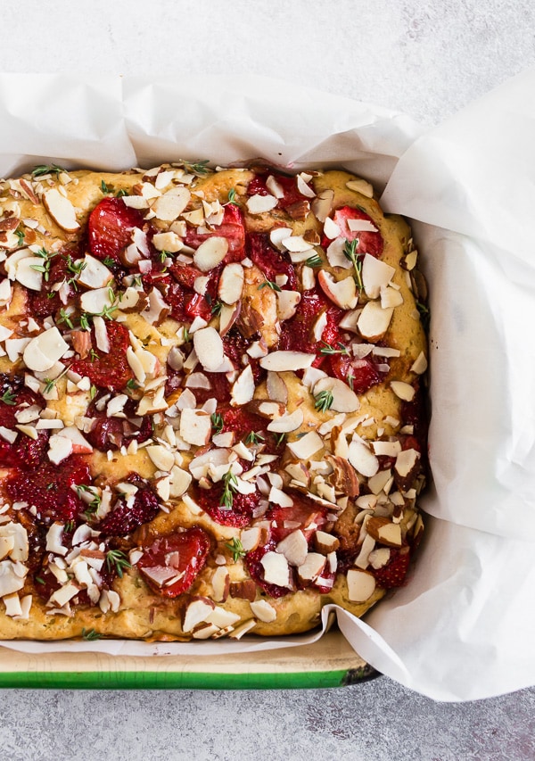 Roasted Strawberry Olive Oil Cake in a baking dish with parchment paper. 