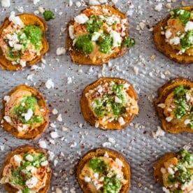 These pesto hummus sweet potato bites are the perfect bite size appetizer. Sumac roasted sweet potato rounds topped with spicy hummus, drizzled with spinach pesto and sprinkled with crumbled feta - how delicious is that!