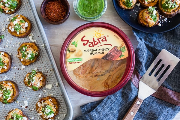 These pesto hummus sweet potato bites are the perfect bite size appetizer. Sumac roasted sweet potato rounds topped with spicy hummus, drizzled with spinach pesto and sprinkled with crumbled feta - how delicious is that!