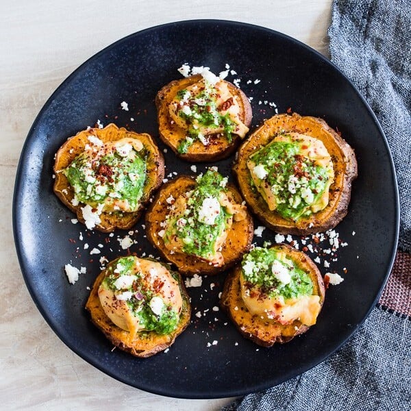 These pesto hummus sweet potato bites are the perfect bite size appetizer. Sumac roasted sweet potato rounds topped with spicy hummus, drizzled with spinach pesto and sprinkled with crumbled feta - how delicious is that!