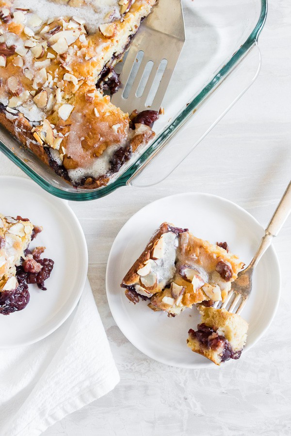 Cherry Fritter Cake in a 9x9 dish and 2 slices on white plates. 