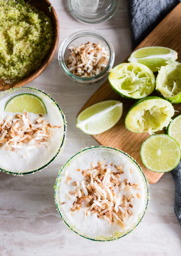 coconut lime frozen margarita served with extra lime slices.