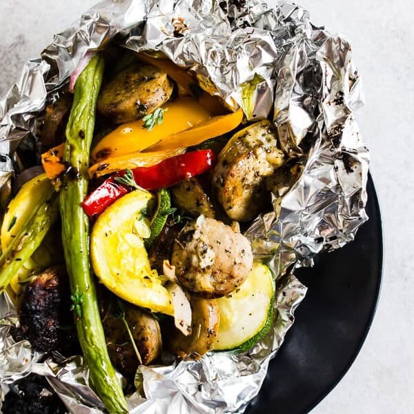 This chicken sausage and vegetable foil packet dinner is super simple to make and perfect for summer. Packed full of chicken sausage, sweet peppers, zucchini, yellow squash, red onion, green beans and drizzled with a herbed olive oil. You'll love this simple dinnertime recipe!