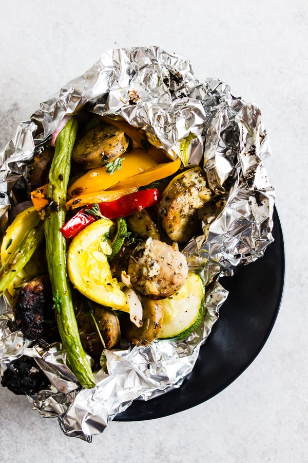 This chicken sausage and vegetable foil packet dinner is super simple to make and perfect for summer. Packed full of chicken sausage, sweet peppers, zucchini, yellow squash, red onion, green beans and drizzled with a herbed olive oil. You'll love this simple dinnertime recipe!