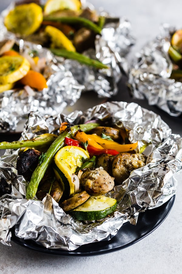 This chicken sausage and vegetable foil packet dinner is super simple to make and perfect for summer. Packed full of chicken sausage, sweet peppers, zucchini, yellow squash, red onion, green beans and drizzled with a herbed olive oil. You'll love this simple dinnertime recipe!