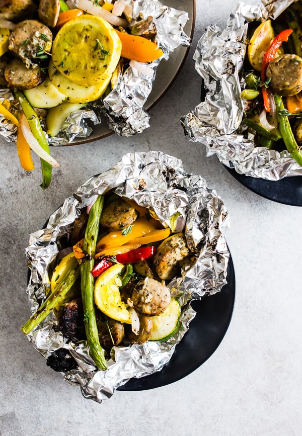 This chicken sausage and vegetable foil packet dinner is super simple to make and perfect for summer. Packed full of chicken sausage, sweet peppers, zucchini, yellow squash, red onion, green beans and drizzled with a herbed olive oil. You'll love this simple dinnertime recipe!