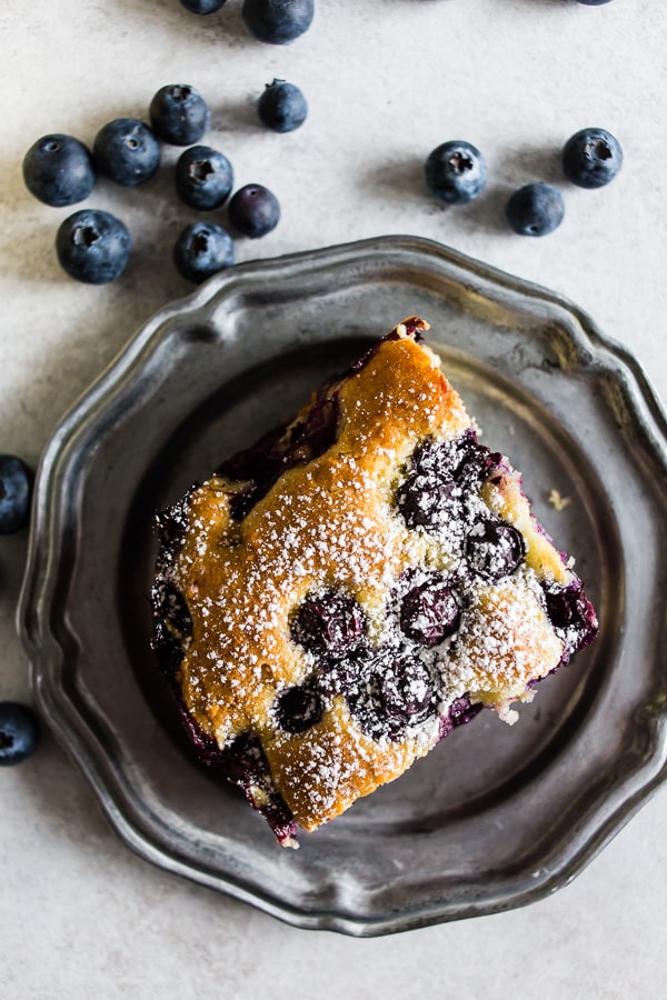 Blueberry Lemon Ricotta Olive Oil Cake sprinkled with powdered sugar.
