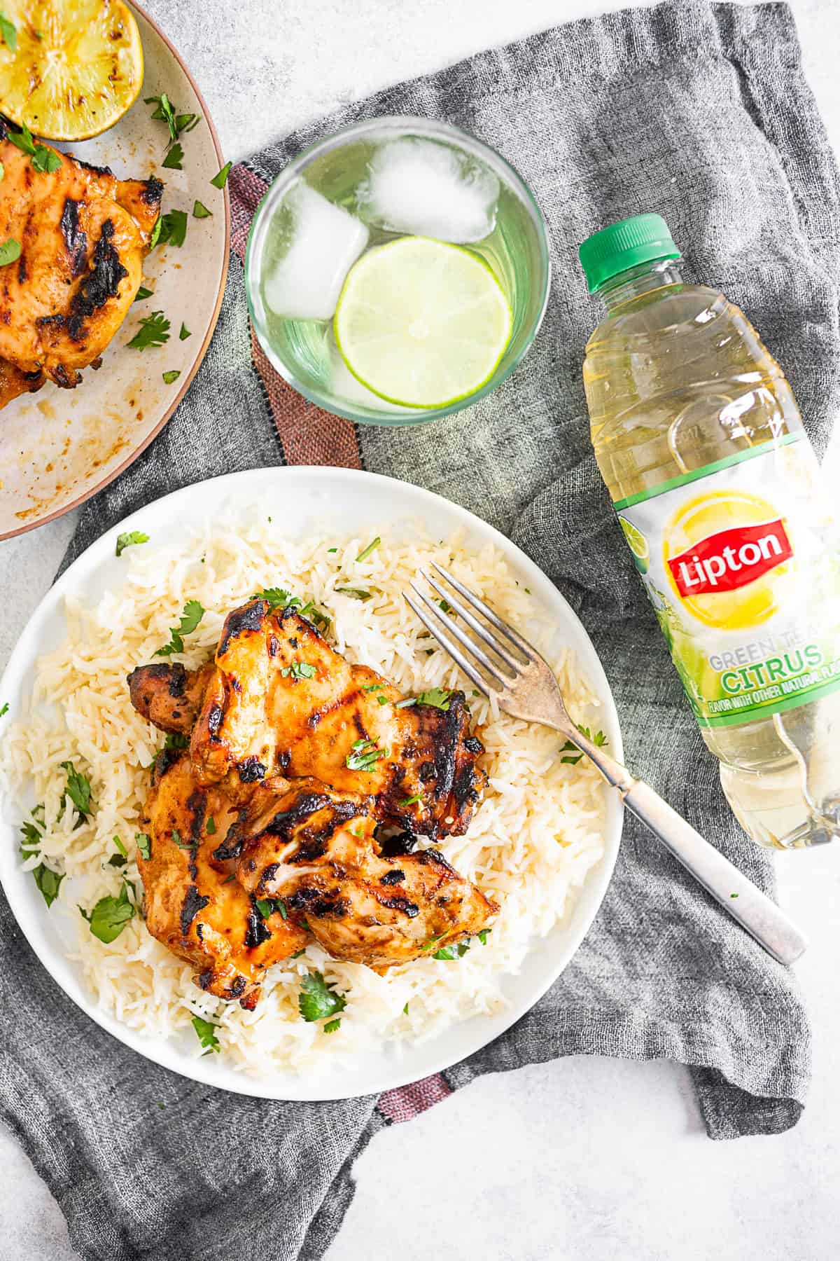 chili lime chicken thighs on a plate with rice and a fork. 