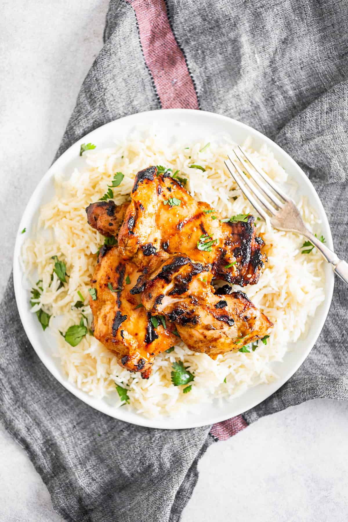 chili lime chicken thighs on a plate with rice. 