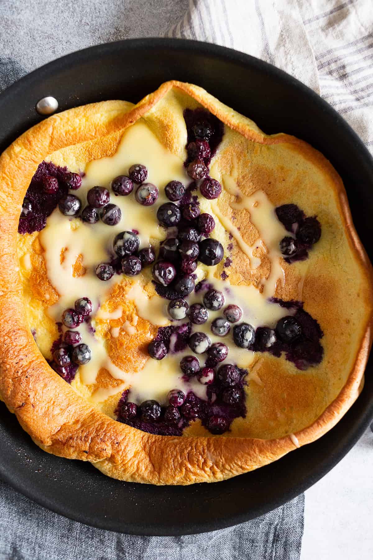 Blueberry Dutch Baby drizzled with lemon curd.