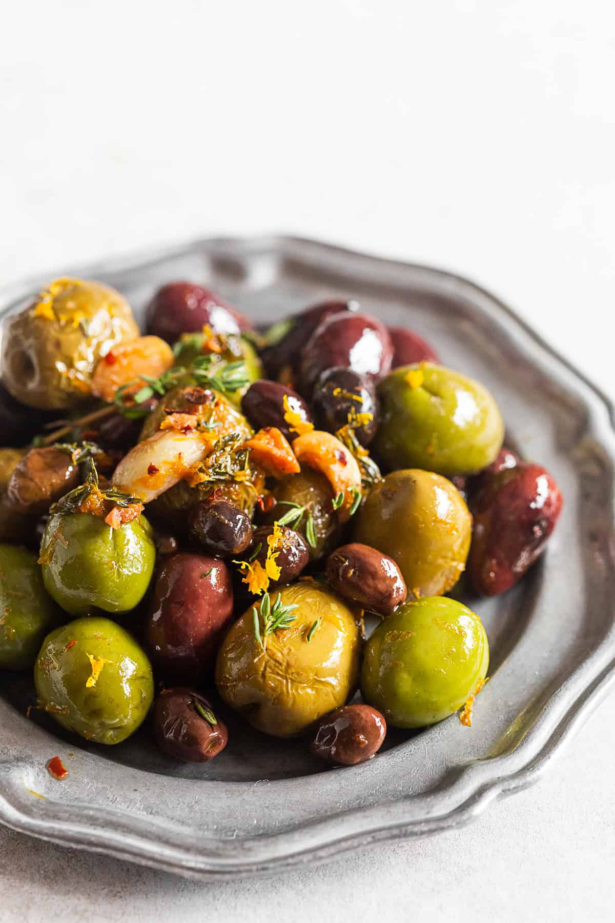 Garlic Herb Roasted Olives on a metal plate. 
