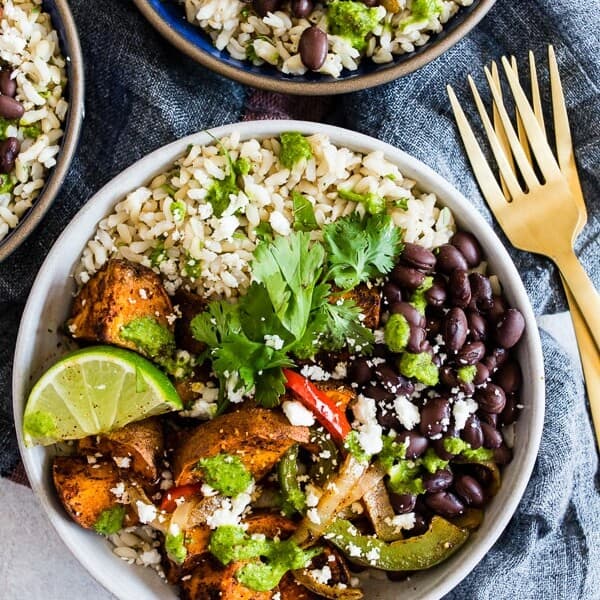These sweet potato black bean burrito bowls are the perfect vegetarian meal to add to your weekly meal plan. Delicious cilantro lime rice piled high with black beans, roasted sweet potatoes, and vegetables. Trust me, you’ll go crazy over this bowl!