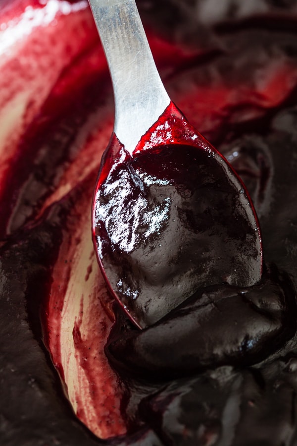 Vanilla Bean Plum Butter in a pot on a spoon. 