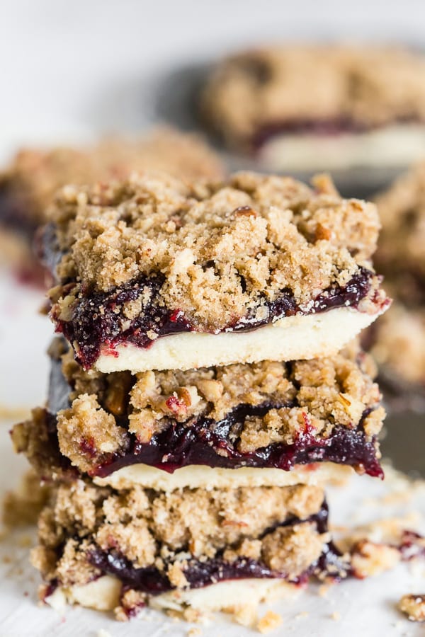 Vanilla Bean Plum Butter Crumble Bars stacked on top of each other. 