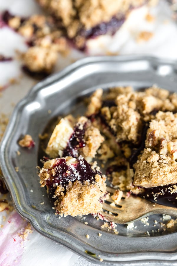 A fork taking a bite of Vanilla Bean Plum Butter Crumble Bars.