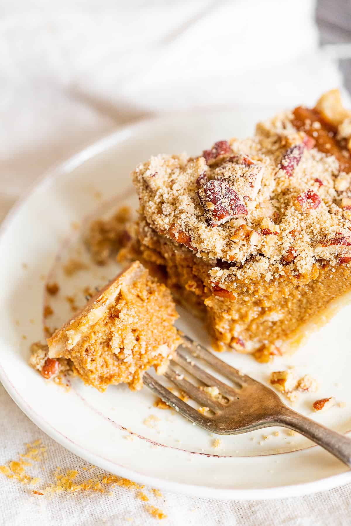 Streusel Topped Apple Butter Pumpkin Pie slice on a plate with a fork.