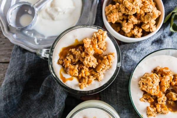 Caramel Apple Crisp Milkshake in a glass topped with granola. 