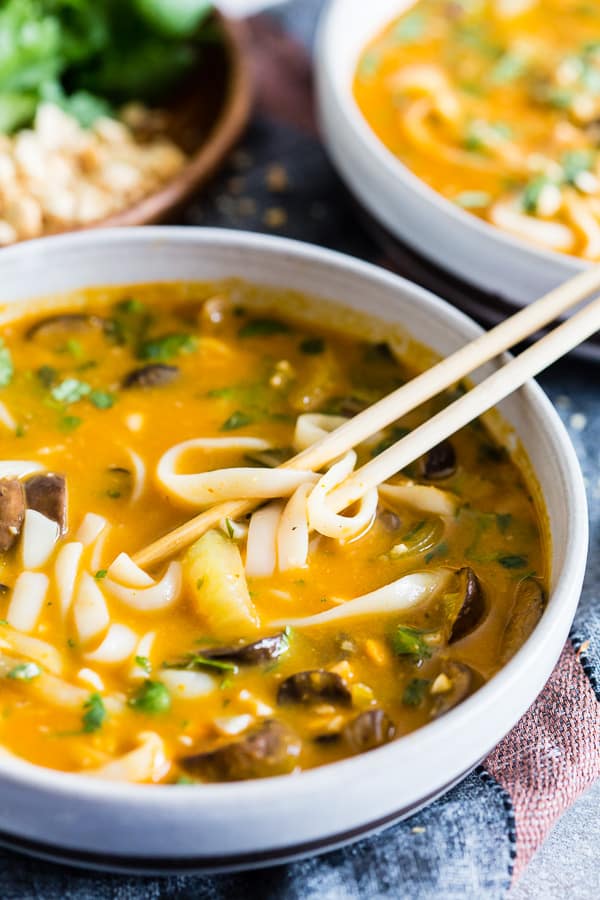 Vegan Red Curry Pumpkin Noodle Soup in a bowl with chopsticks. 