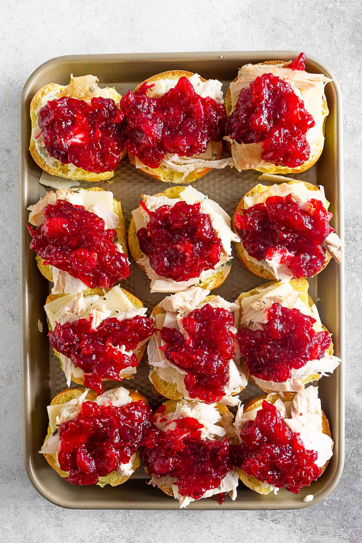 Baked Cranberry Cheddar Turkey Sandwiches on a baking tray.