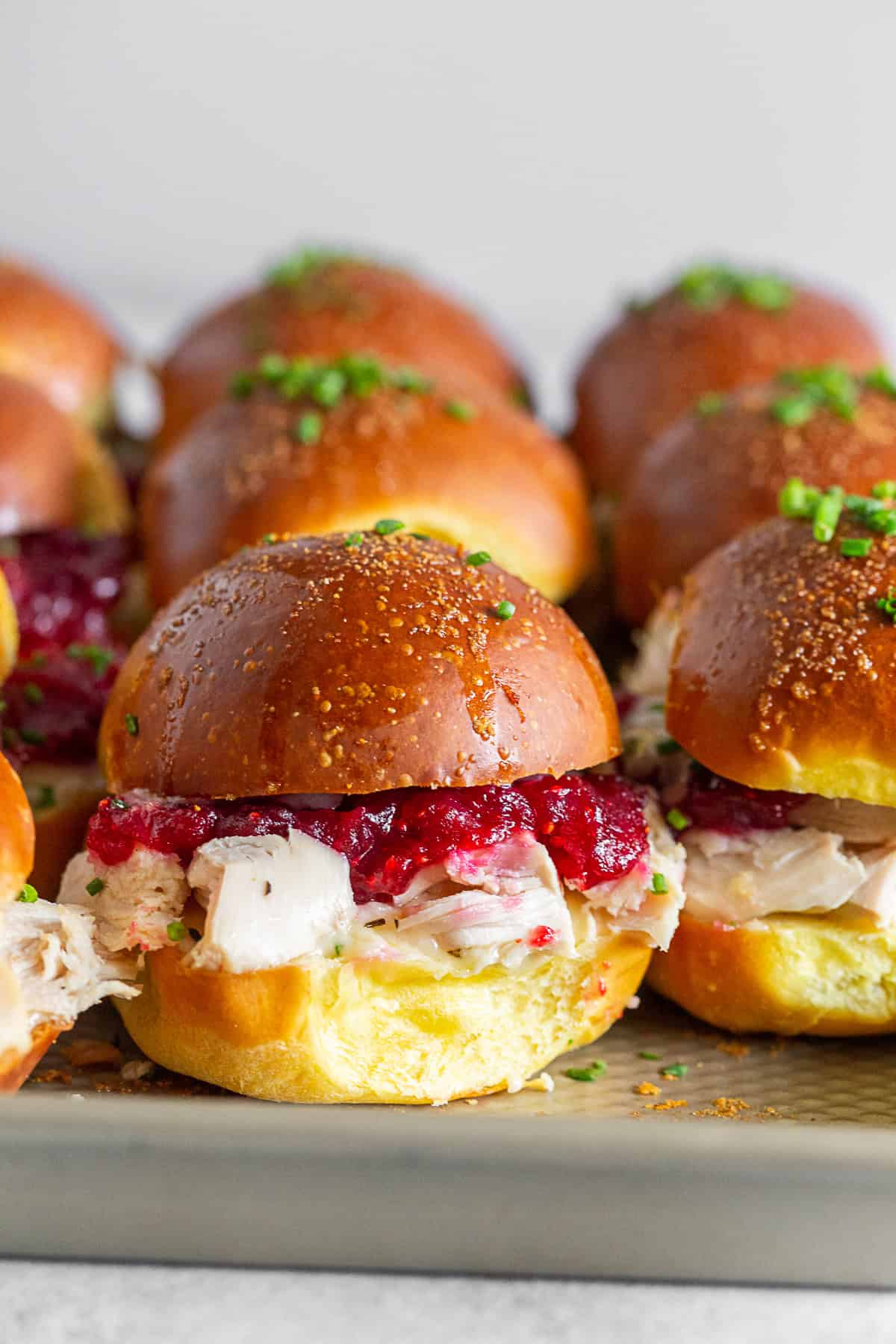 baked turkey and cranberry sandwiches on a sheet pan.
