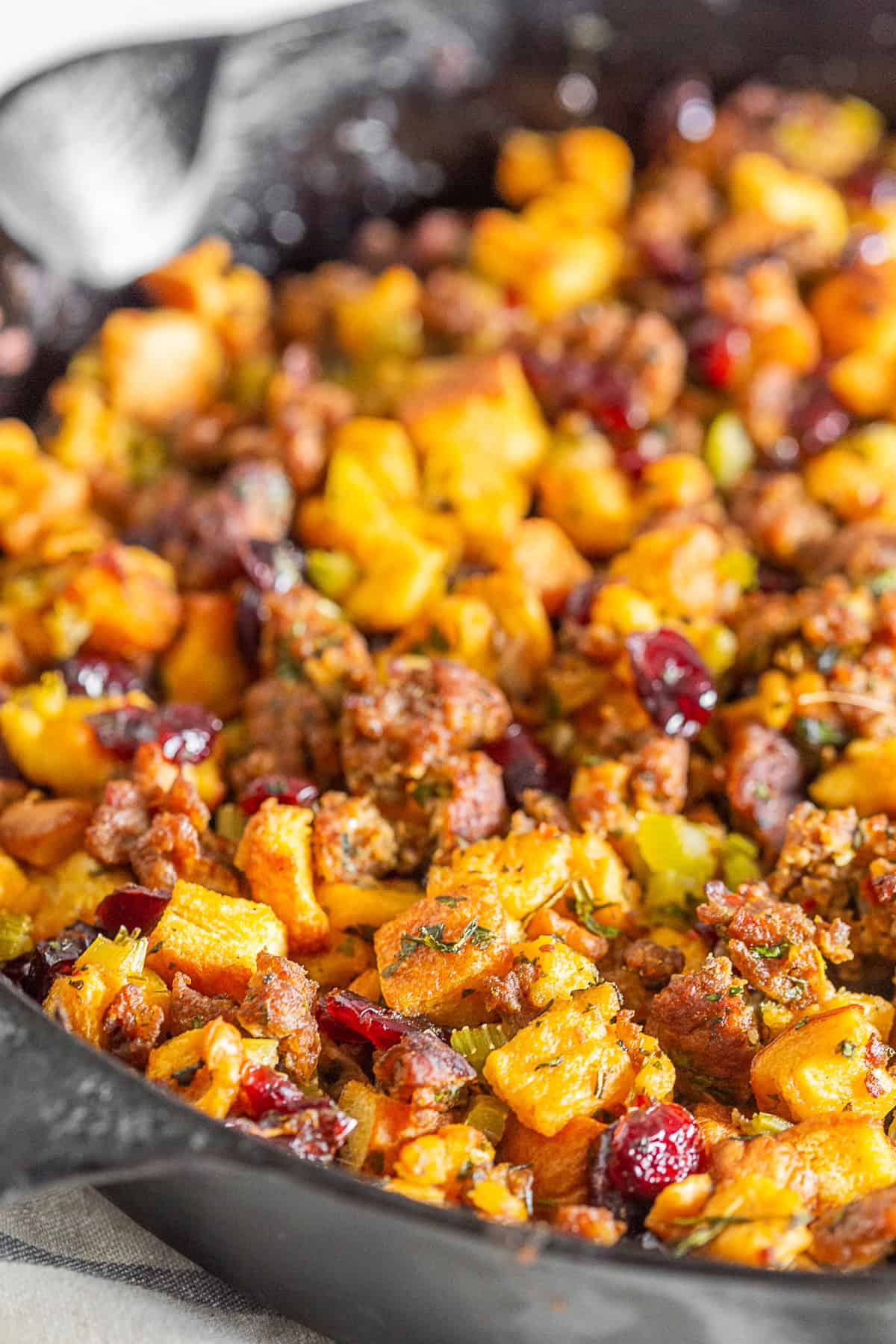 Potato Bread Sausage Cranberry Stuffing in a skillet on a table. 