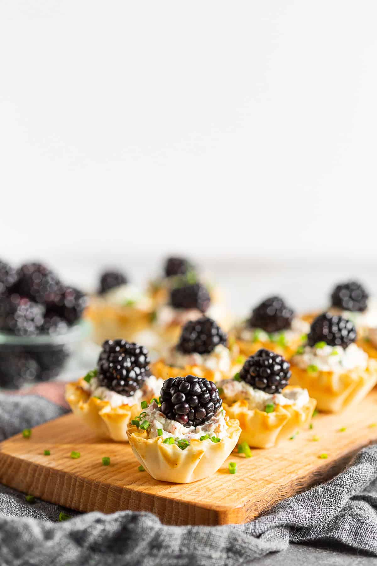 Goat Cheese Prosciutto Phyllo Bites topped with a blackberry.