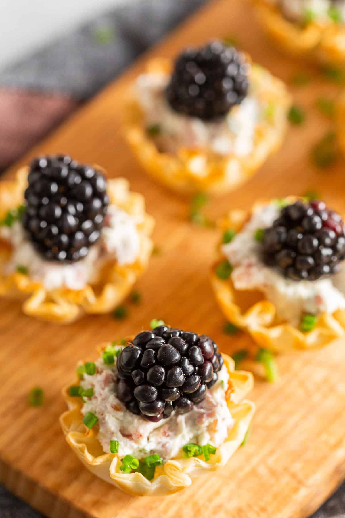 Goat Cheese Prosciutto Phyllo Bites topped with chives.