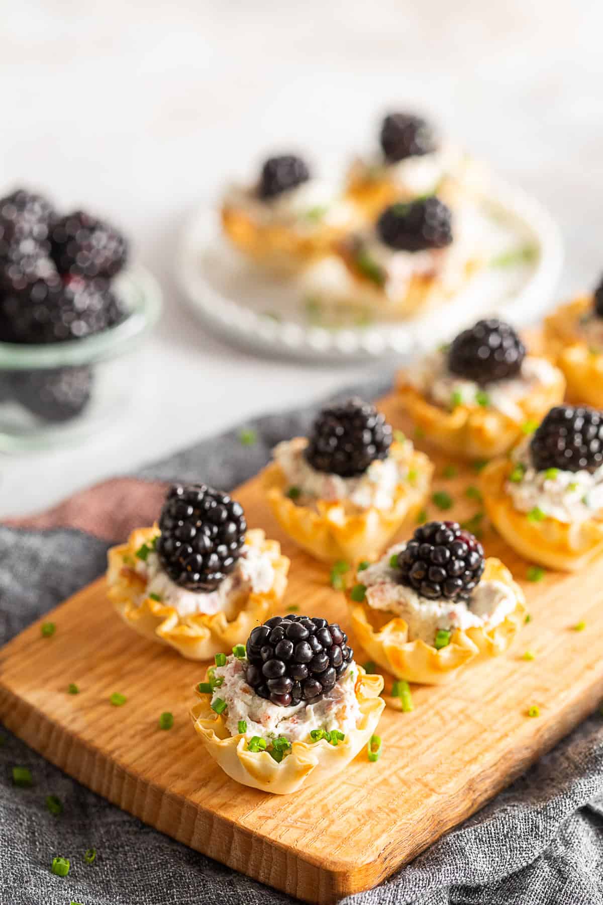 Goat Cheese Prosciutto Phyllo Bites on a wooden board.