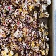 This peppermint bark popcorn is the EASIEST Christmas candy snack ever! Lightly buttered popcorn topped with white chocolate, dark chocolate, crushed candy canes, and sprinkles. You'll love this flavor packed snack!