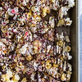 This peppermint bark popcorn is the EASIEST Christmas candy snack ever! Lightly buttered popcorn topped with white chocolate, dark chocolate, crushed candy canes, and sprinkles. You'll love this flavor packed snack!