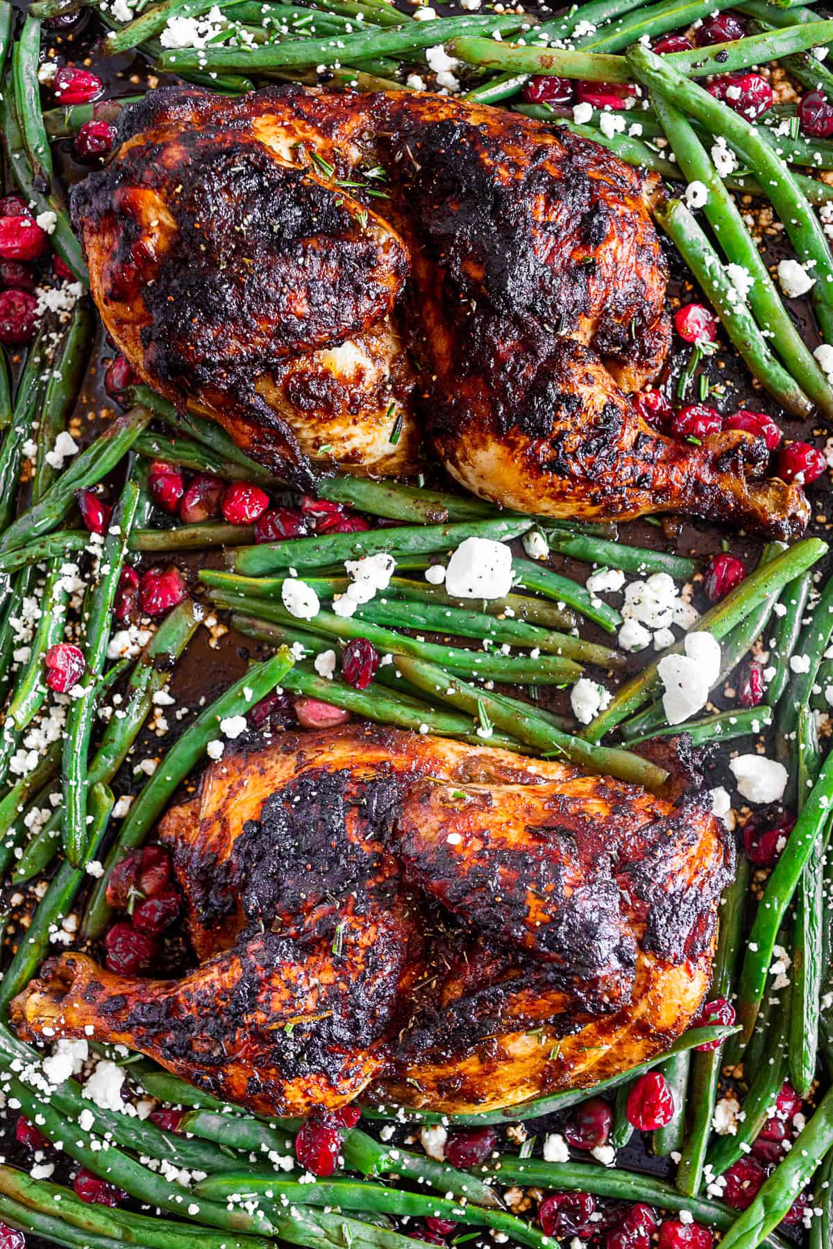 Sheet Pan Balsamic Chicken with Cranberry and Green Beans on a sheet pan sprinkled with goat cheese.