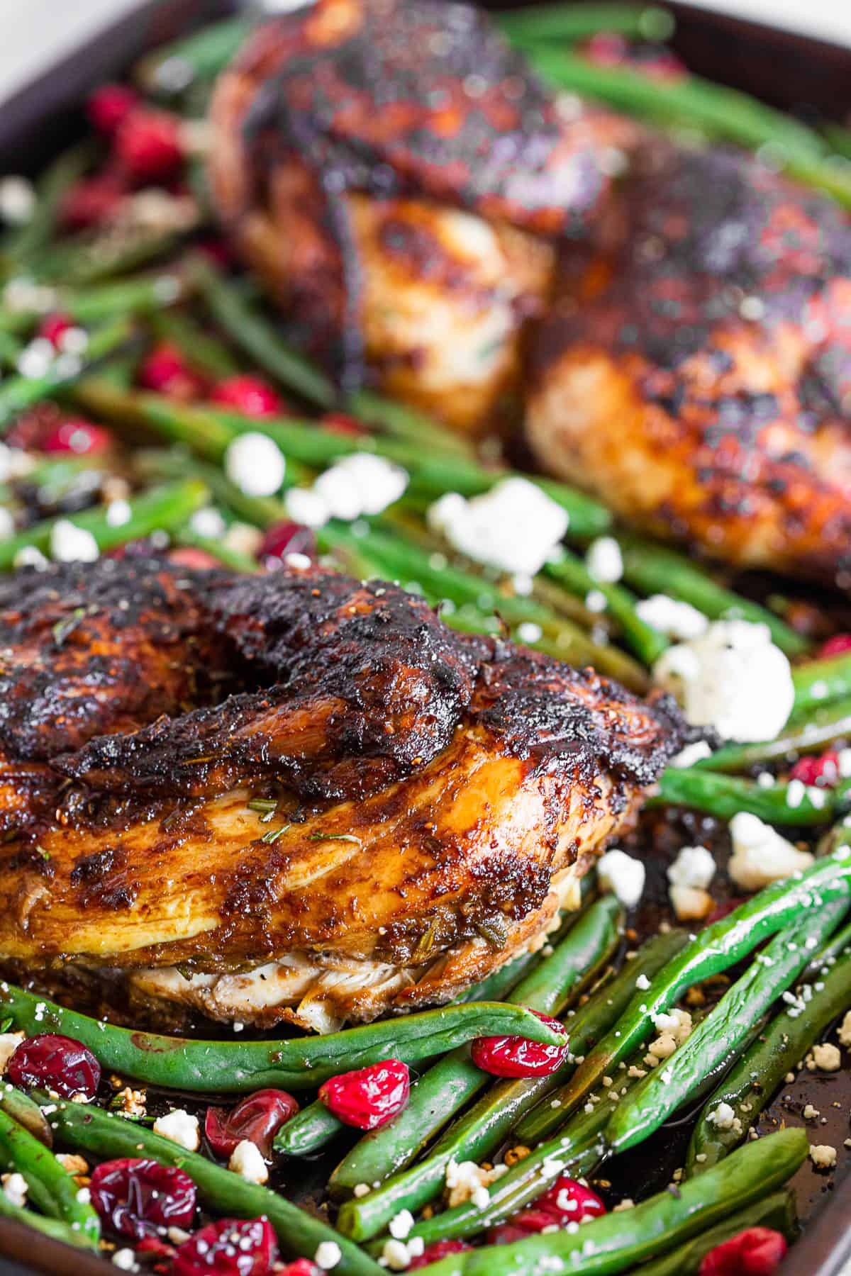 Marinated balsamic chicken on a sheet pan with green beans.