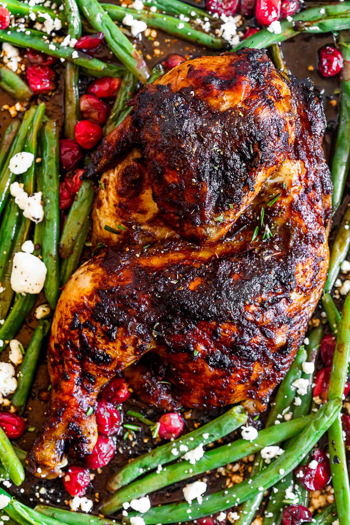 Sheet Pan Balsamic Chicken with Cranberry and Green Beans sprinkled with fresh rosemary and goat cheese.