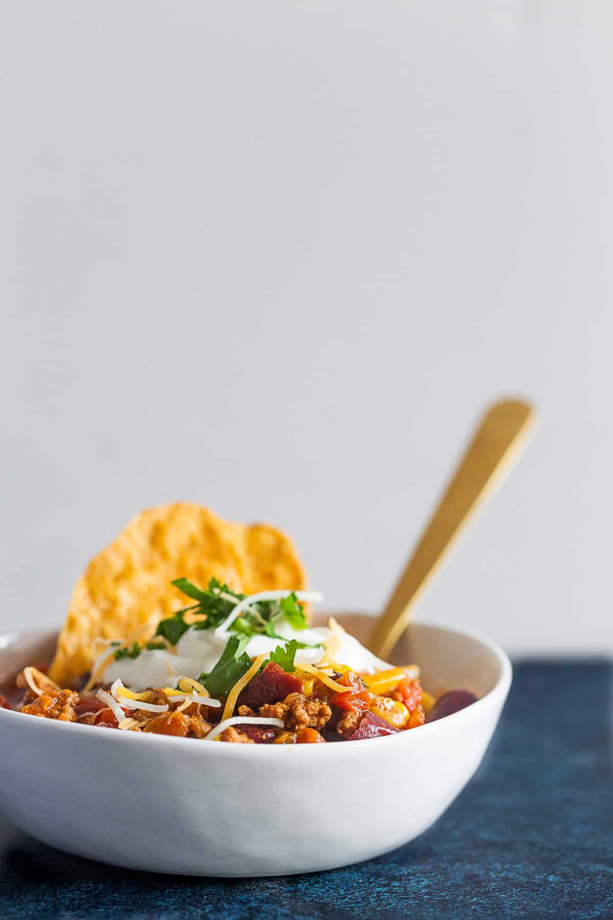 Chipotle Ground Turkey Chili spooned in a bowl with a spoon. 