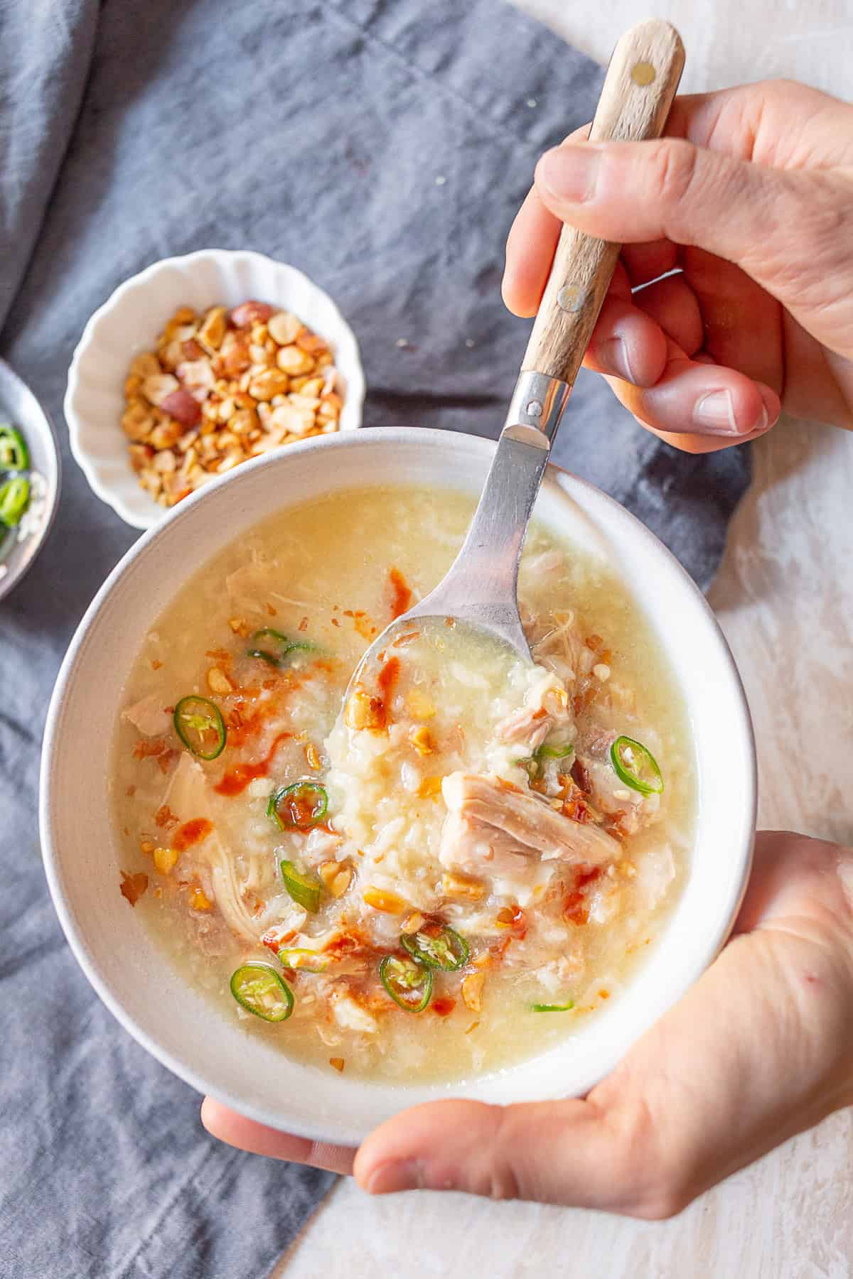 A person holding a bowl of Instant Pot Asian Chicken and Rice Soup. 
