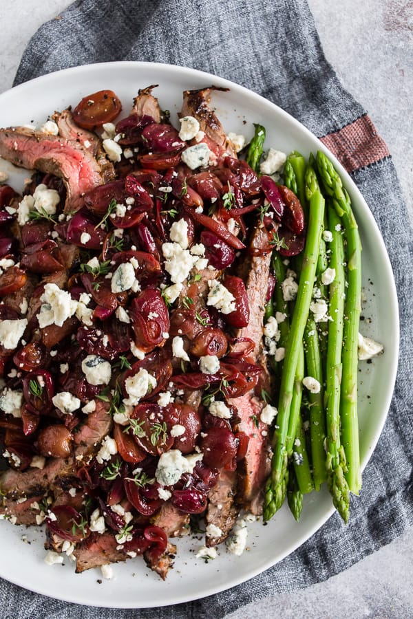 Grape and Blue Cheese Flank Steak served with asparagus.