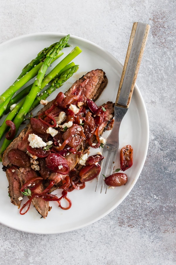Grape and Blue Cheese Flank Steak served on a plate with a fork.