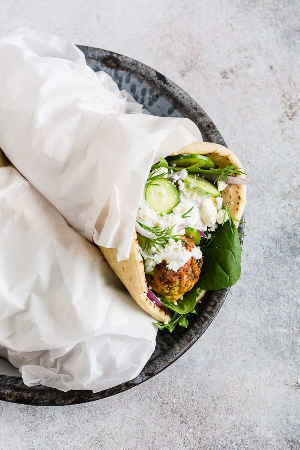 Greek Chicken Meatball Gyros wrapped in parchment paper.